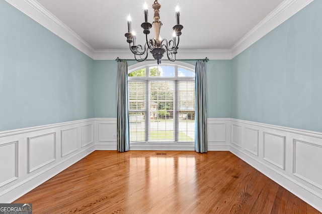 160 Torrey Pines Ct, Newnan, GA 30265 - spare room with a chandelier, a wainscoted wall, ornamental molding, wood finished floors, and a decorative wall