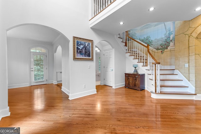 160 Torrey Pines Ct, Newnan, GA 30265 - entrance foyer featuring wood finished floors, stairway, baseboards, a towering ceiling, and crown molding