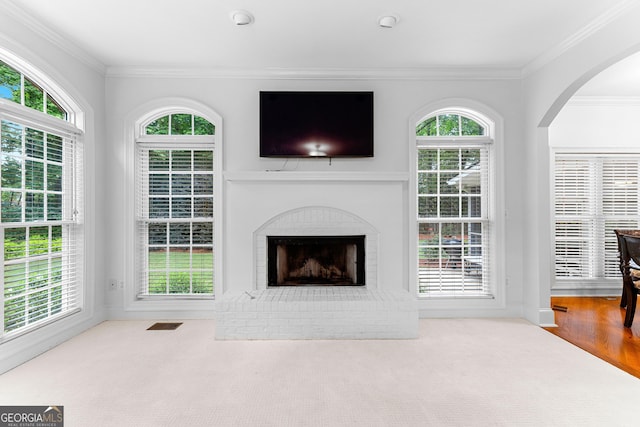 160 Torrey Pines Ct, Newnan, GA 30265 - unfurnished living room featuring ornamental molding, healthy amount of natural light, a brick fireplace, and arched walkways