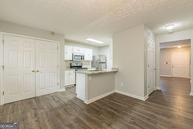 3151 Kingswood Gln, Decatur, GA 30034 - kitchen with stainless steel appliances, white cabinets, baseboards, a sink, and a peninsula