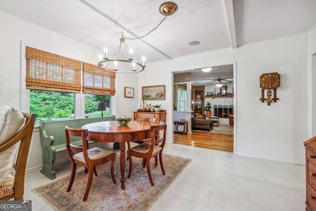 4442 Mclain Cir, Acworth, GA 30101 - dining space featuring a chandelier, a large fireplace, beam ceiling, and a ceiling fan