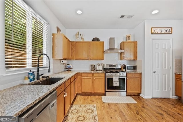 130 Nacoochee Way, Canton, GA 30114 - kitchen featuring stainless steel appliances, wall chimney exhaust hood, light wood finished floors, decorative backsplash, and light stone counters