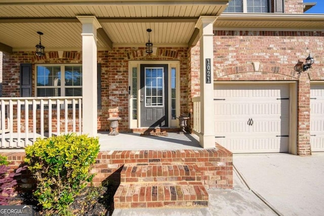 1021 Reddy Farm Rd, Grayson, GA 30017 - property entrance with a porch, brick siding, concrete driveway, and a garage