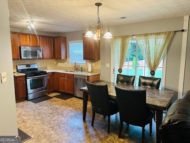 789 Winbrook Dr Unit 1, Mcdonough, GA 30253 - kitchen featuring stainless steel appliances, tasteful backsplash, light countertops, a chandelier, and a textured ceiling