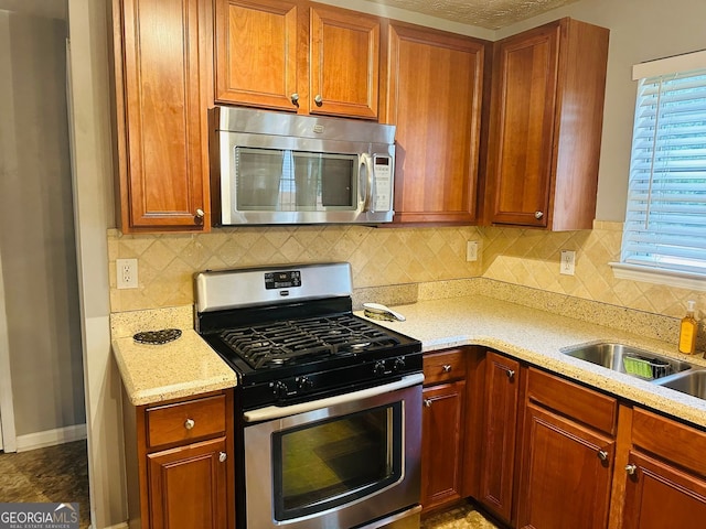 789 Winbrook Dr Unit 1, Mcdonough, GA 30253 - kitchen featuring appliances with stainless steel finishes, light stone countertops, backsplash, and brown cabinets