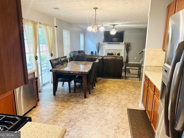789 Winbrook Dr Unit 1, Mcdonough, GA 30253 - dining space featuring a ceiling fan, a textured ceiling, a fireplace, and light floors