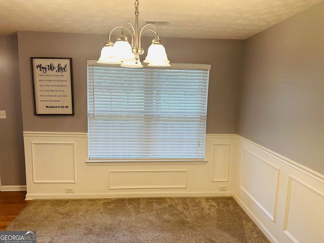 789 Winbrook Dr Unit 1, Mcdonough, GA 30253 - unfurnished dining area featuring a chandelier, a textured ceiling, wainscoting, and a decorative wall