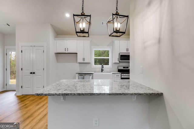 560 Coots Lake Rd, Rockmart, GA 30153 - kitchen with appliances with stainless steel finishes, white cabinets, a breakfast bar area, and a peninsula