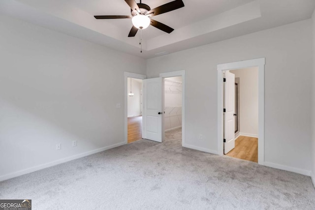 560 Coots Lake Rd, Rockmart, GA 30153 - unfurnished bedroom with carpet floors, a walk in closet, a closet, a tray ceiling, and a ceiling fan