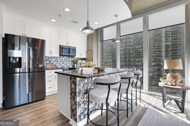 855 Peachtree St NE Unit 1703, Atlanta, GA 30308 - kitchen featuring stainless steel appliances, dark countertops, white cabinetry, expansive windows, and decorative backsplash
