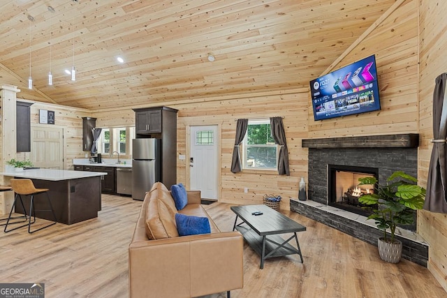 139 Maple Ridge Dr, Cleveland, GA 30528 - living area featuring lofted ceiling, light wood-style flooring, wooden walls, healthy amount of natural light, and a fireplace