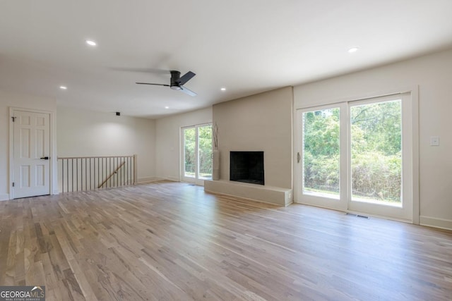 3350 Pine Meadow Rd NW, Atlanta, GA 30327 - unfurnished living room featuring light wood-style floors, recessed lighting, a ceiling fan, and a fireplace with raised hearth