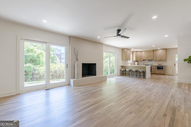 3350 Pine Meadow Rd NW, Atlanta, GA 30327 - unfurnished living room with recessed lighting, light wood-style floors, ceiling fan, and a fireplace with raised hearth