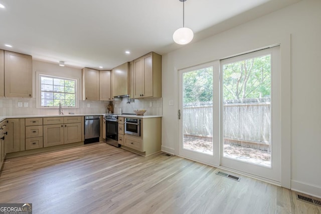 3350 Pine Meadow Rd NW, Atlanta, GA 30327 - kitchen with stainless steel appliances, tasteful backsplash, light wood-type flooring, light countertops, and decorative light fixtures