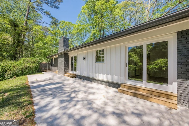 3350 Pine Meadow Rd NW, Atlanta, GA 30327 - view of side of property featuring brick siding, a chimney, and board and batten siding