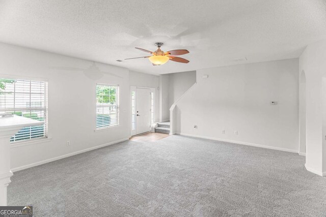 3134 Imperial Cir SW, Atlanta, GA 30311 - unfurnished living room with arched walkways, a ceiling fan, carpet, and a textured ceiling