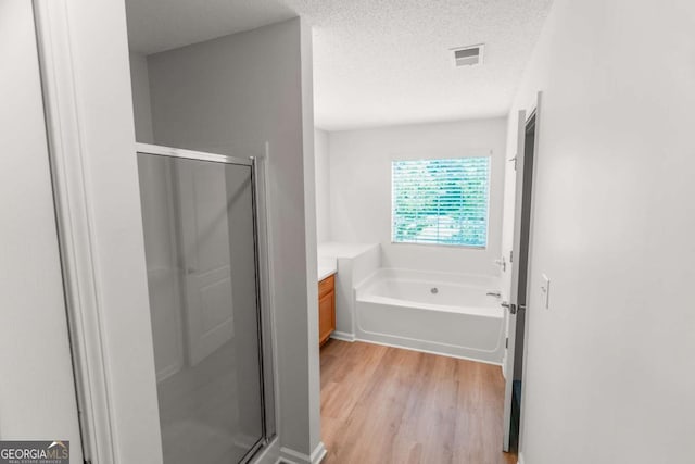 3134 Imperial Cir SW, Atlanta, GA 30311 - full bath with a shower stall, wood finished floors, a textured ceiling, a bath, and vanity