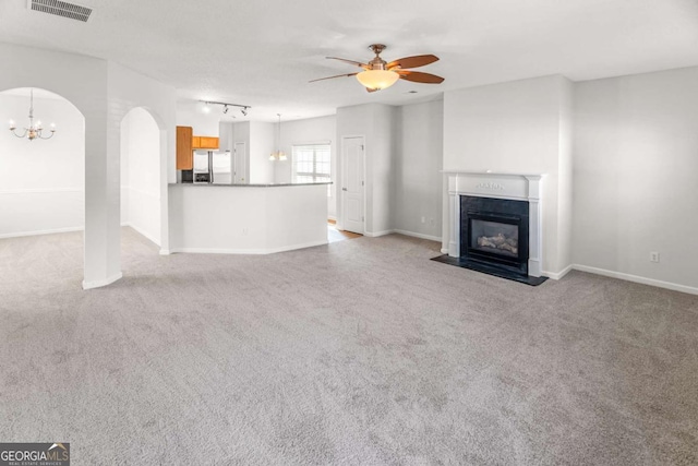 3134 Imperial Cir SW, Atlanta, GA 30311 - unfurnished living room featuring a ceiling fan, a chandelier, carpet floors, a fireplace with flush hearth, and arched walkways