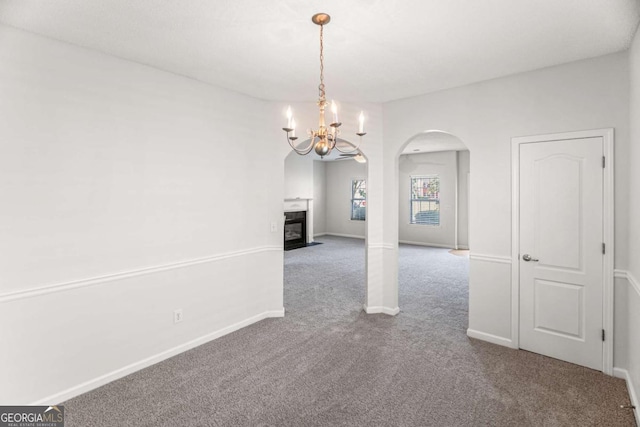 3134 Imperial Cir SW, Atlanta, GA 30311 - unfurnished dining area featuring arched walkways, carpet, a fireplace with flush hearth, and a chandelier