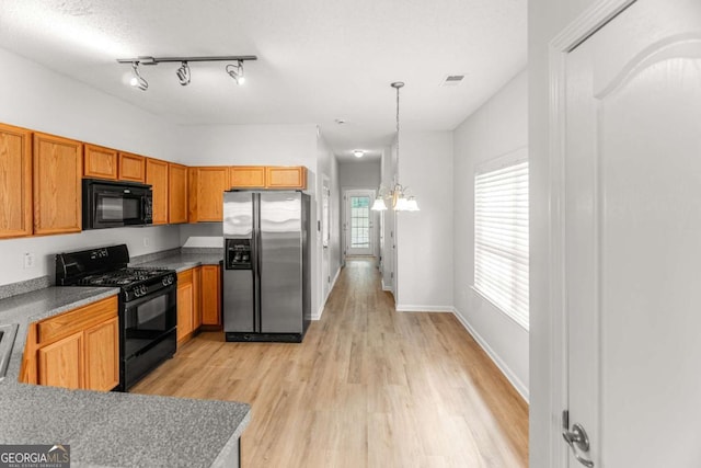3134 Imperial Cir SW, Atlanta, GA 30311 - kitchen with black appliances, a chandelier, light wood-style flooring, and pendant lighting