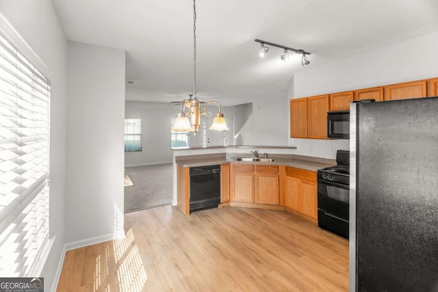 3134 Imperial Cir SW, Atlanta, GA 30311 - kitchen featuring black appliances, a peninsula, light wood-type flooring, hanging light fixtures, and open floor plan