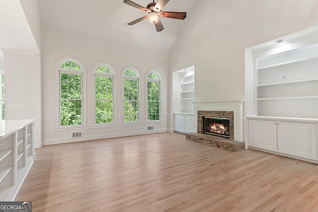 140 Longwater Cv, Roswell, GA 30075 - unfurnished living room with ceiling fan, built in shelves, plenty of natural light, light wood-style floors, and high vaulted ceiling