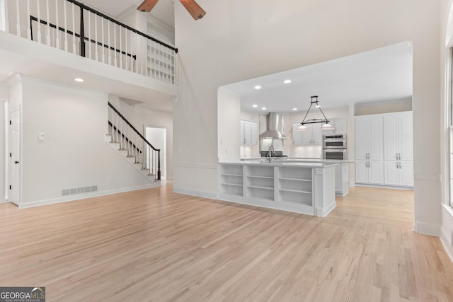 140 Longwater Cv, Roswell, GA 30075 - unfurnished living room featuring baseboards, light wood-style floors, ceiling fan, recessed lighting, and a high ceiling