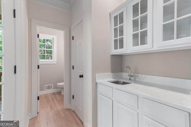 140 Longwater Cv, Roswell, GA 30075 - indoor wet bar featuring light wood-style floors, ornamental molding, and baseboards