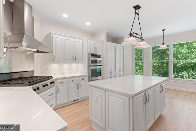 140 Longwater Cv, Roswell, GA 30075 - kitchen with wall chimney range hood, appliances with stainless steel finishes, ornamental molding, a kitchen island, and white cabinetry