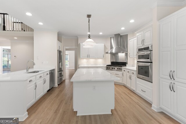 140 Longwater Cv, Roswell, GA 30075 - kitchen with wall chimney range hood, stainless steel appliances, a center island, a peninsula, and ornamental molding