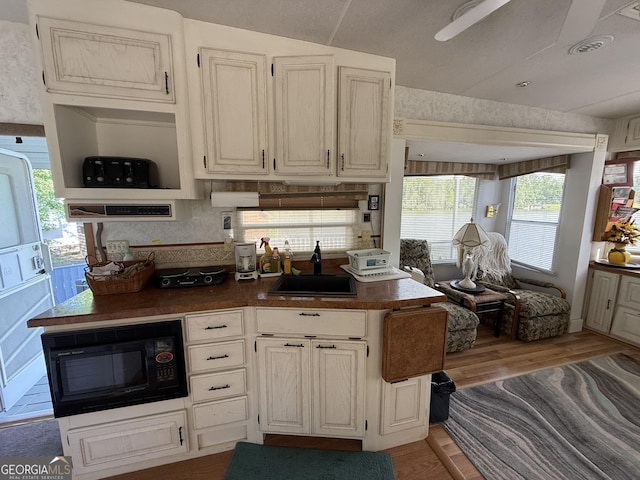 1031 Mountain Shadows Dr Unit 90A, Cleveland, GA 30528 - kitchen featuring black microwave, a sink, light wood-style flooring, dark countertops, and ceiling fan