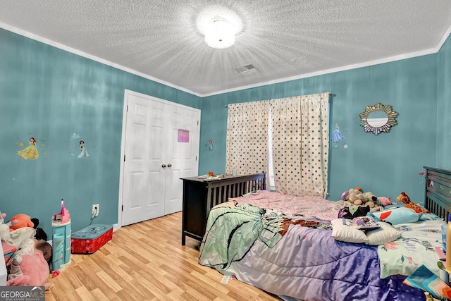3897 Tanbark Ct, Marietta, GA 30066 - bedroom featuring crown molding, wood finished floors, a textured ceiling, and a closet