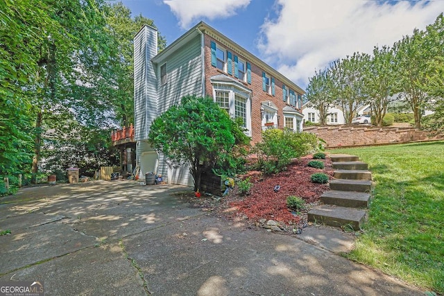 3897 Tanbark Ct, Marietta, GA 30066 - view of home's exterior featuring a chimney, driveway, an attached garage, and a lawn