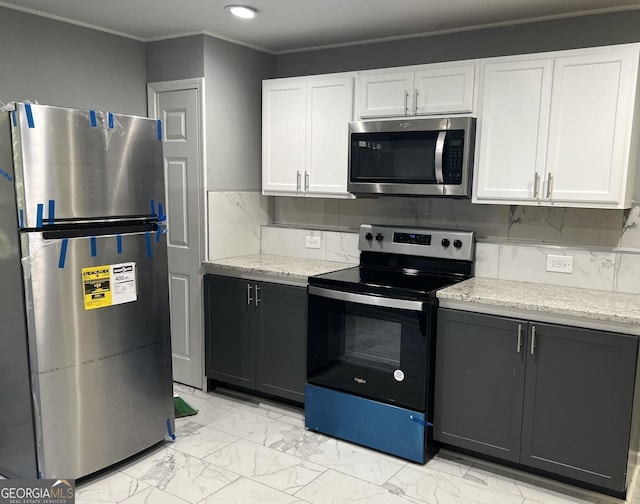 30 Highlands Ln, Oxford, GA 30054 - kitchen featuring appliances with stainless steel finishes, white cabinetry, ornamental molding, light marble finish floors, and light stone countertops