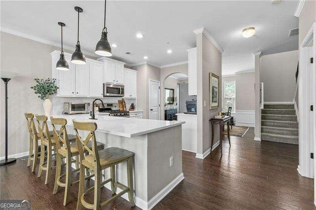 3386 Vintage Cir SE Unit 8, Smyrna, GA 30080 - kitchen with stainless steel appliances, ornamental molding, dark wood-type flooring, a peninsula, and white cabinetry