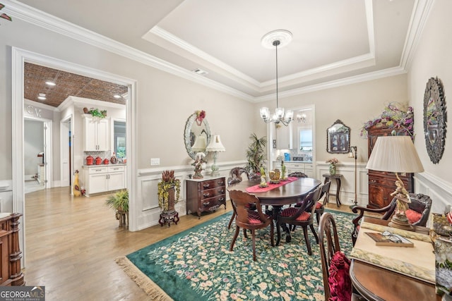 332 Rosshandler Rd, Suwanee, GA 30024 - dining area with a chandelier, light wood finished floors, crown molding, wainscoting, and a raised ceiling