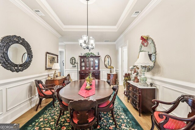 332 Rosshandler Rd, Suwanee, GA 30024 - dining space with a tray ceiling, a chandelier, light wood finished floors, a decorative wall, and a wainscoted wall