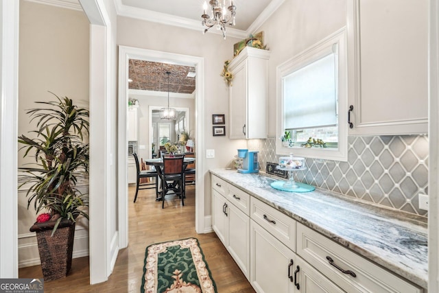 332 Rosshandler Rd, Suwanee, GA 30024 - kitchen featuring a chandelier, crown molding, white cabinetry, light wood-type flooring, and light stone countertops