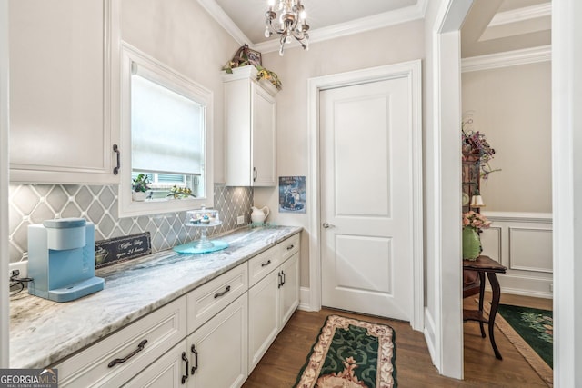 332 Rosshandler Rd, Suwanee, GA 30024 - kitchen featuring dark wood-style flooring, white cabinetry, decorative backsplash, crown molding, and a chandelier