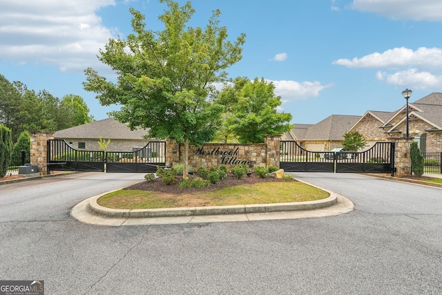 332 Rosshandler Rd, Suwanee, GA 30024 - view of asphalt road featuring a gate, curbs, and a gated entry