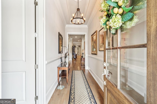 332 Rosshandler Rd, Suwanee, GA 30024 - corridor with a chandelier, wood finished floors, ornamental molding, and a wainscoted wall