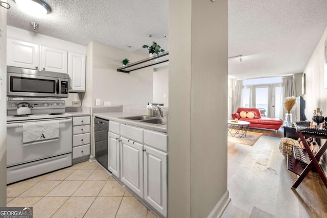 375 Ralph Mcgill Blvd NE Unit 707, Atlanta, GA 30312 - kitchen featuring stainless steel microwave, electric range, dishwashing machine, a textured ceiling, and a sink