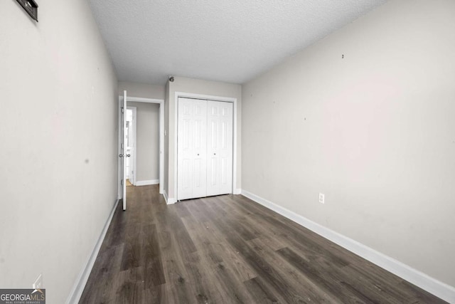 375 Ralph Mcgill Blvd NE Unit 707, Atlanta, GA 30312 - unfurnished bedroom with dark wood-style flooring, baseboards, a textured ceiling, and a closet
