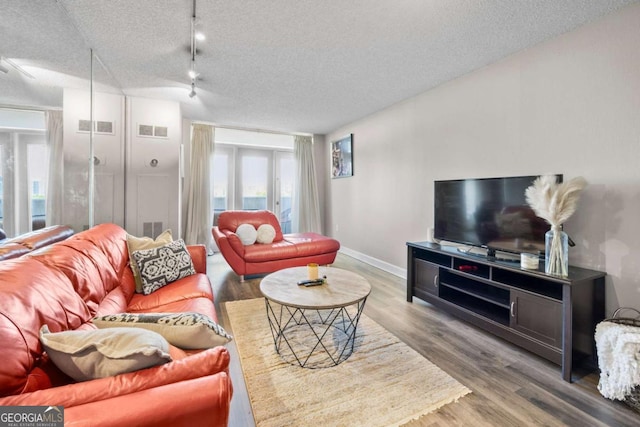 375 Ralph Mcgill Blvd NE Unit 707, Atlanta, GA 30312 - living room with wood finished floors, a textured ceiling, baseboards, and rail lighting