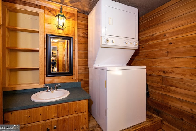 230 Kelly Dr, Hamilton, GA 31811 - washroom with stacked washer and clothes dryer, wooden walls, and built in shelves