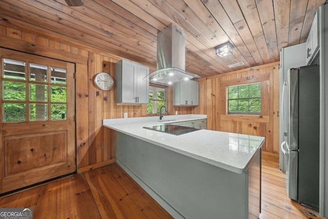 853 Bates Rd, Ellijay, GA 30540 - kitchen with freestanding refrigerator, island exhaust hood, wood walls, a peninsula, and wooden ceiling