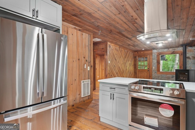 853 Bates Rd, Ellijay, GA 30540 - kitchen with appliances with stainless steel finishes, heating unit, wooden ceiling, light wood-style floors, and wooden walls