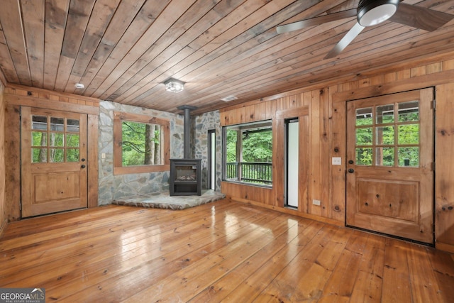 853 Bates Rd, Ellijay, GA 30540 - unfurnished living room featuring healthy amount of natural light, wood ceiling, a wood stove, wood walls, and a ceiling fan