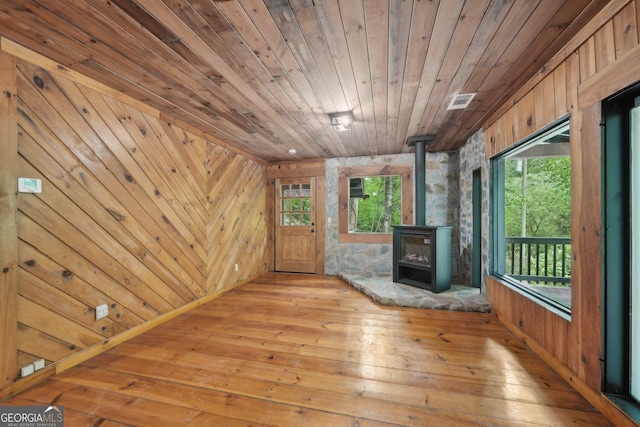 853 Bates Rd, Ellijay, GA 30540 - unfurnished living room with a wood stove, hardwood / wood-style flooring, wooden ceiling, and wooden walls