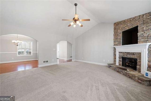 85 Stiles Dr, Dallas, GA 30132 - unfurnished living room with carpet floors, a ceiling fan, arched walkways, a fireplace, and a chandelier